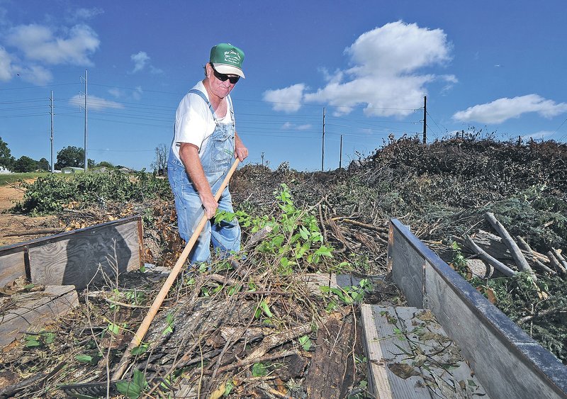 STAFF PHOTO BEN GOFF &#8226; @NWABenGoff Darild Self of Rogers rakes yard waste Wednesday from his trailer at the Rogers Community Recycling Center. The waste was blown down on his property during recent storms, he said.