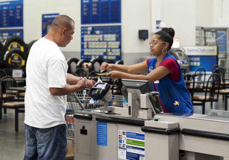  In this June 5, 2014 photo, Conquisia Tyler, right, gives change to a customer at Sam's Club in Bentonville, Ark. The Commerce Department releases retail sales data for July on Wednesday, Aug. 13, 2014.