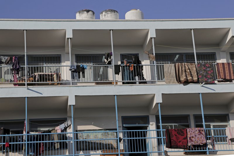 A displaced Palestinian female stands on the balcony of the U.N. school where her family sought refuge during the war, in Beit Lahiya, in the northern Gaza Strip, Tuesday, Aug. 12, 2014. Tens of thousands of Palestinians have been displaced in the Israel-Hamas war that began July 8, at least 10,000 housing units have been destroyed and many have found refuge at U.N. schools turned into shelters.