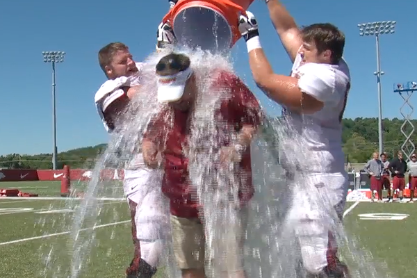 Two Razorbacks dump ice water on head coach Bret Bielema. The challenge, which aims to support ALS research, has been a social media favorite in recent weeks.