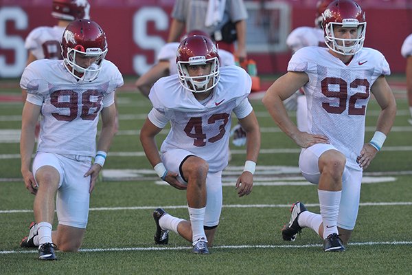 Arkansas kickers (from left to right) Cole Hedlund, John Henson and Sam Irwin-Hill stretch prior to practice Wednesday, Aug. 13, 2014 at Razorback Stadium in Fayetteville.