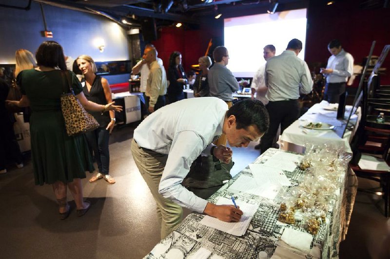 A job seeker leaves his contact information at a table set up by the Union Square Cafe at a career fair held by Union Square Hospitality Group at the Jazz Standard in New York in July.