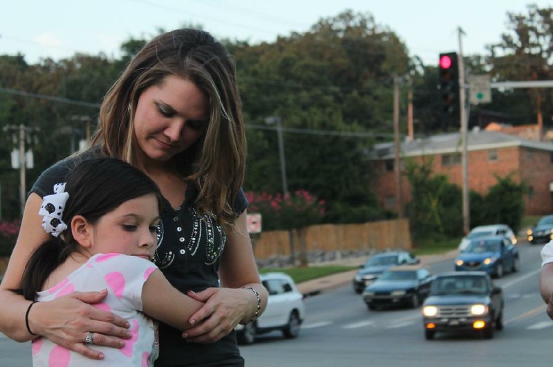 Arkansas Democrat-Gazette/Ashley Nerbovig
Samantha Olson's sister April Welshhons, 26, stands with her daughter on the corner of the intersection where a year earlier Olson was shot and killed while driving with her 11- month daughter. Welshhon said she and Olson had planned to raise their daughters together.

