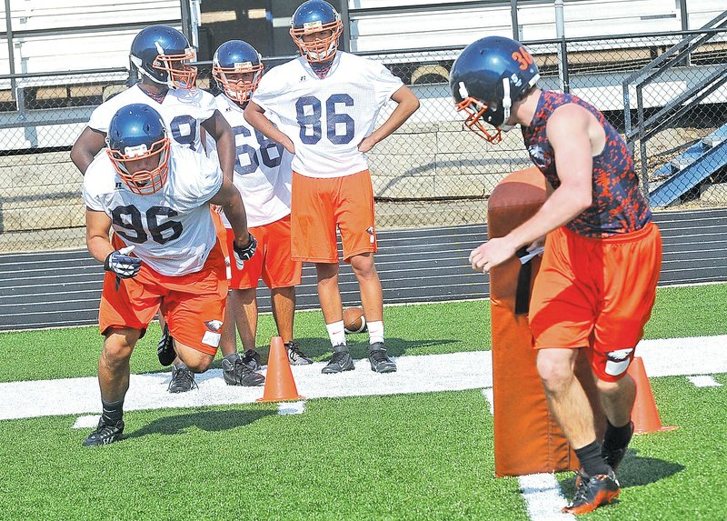  STAFF PHOTO FLIP PUTTHOFF Andy Mendoza, 96, works out with the Rogers Heritage defensive linemen during practice on Aug 5.