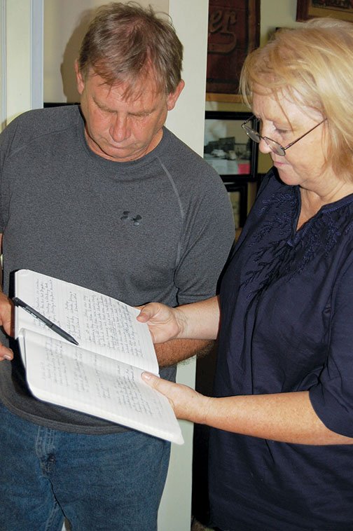 Steve and Darlene Emmons read the Haskell Historical Museum log book about the day broken pipes and water damage to the museum were discovered at the museum building in Haskell. Water could have been running for as long as three weeks, as the museum was closed for an extended period of time during the summer.