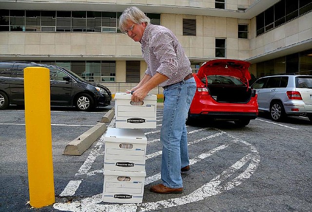 David Couch unloads boxes Friday outside the secretary of state’s office that he says contain petitions with more than 41,000 signatures in this 2014 file photo.