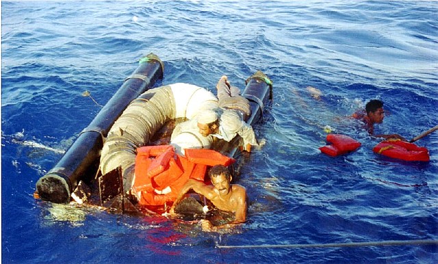 Three Cubans cling to an overturned raft and life preservers about 15 miles north of Cuba in 1994. The U.S. is now seeing a resurgence of Cubans trying to raft to Florida.