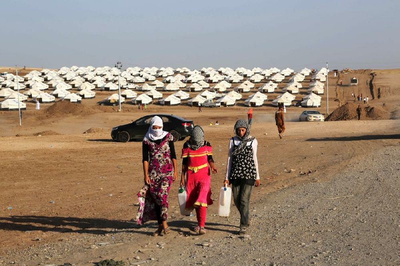 Displaced Iraqi Yazidis settle in Friday at a new refugee camp near Feeshkhabour town at the Syria-Iraq border.