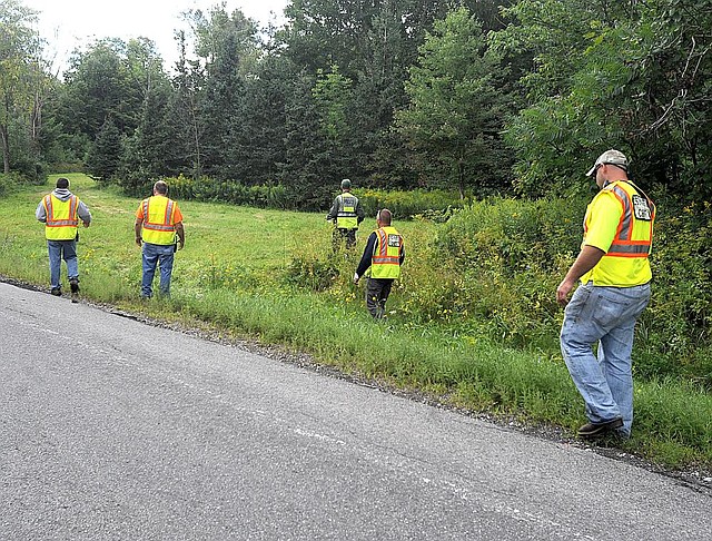 Officials search a roadside field in Oswegatchie, N.Y., on Thursday, Aug. 14, 2104, for clues in the abduction of two Amish girls who were taken from a vegetable stand on the evening before. Amish sisters Delila, 6 and Fannie Miller, 12, were abducted on about 7:30 p.m., Wednesday evening from a vegetable stand in front of their home. (AP Photo/Watertown Daily Times, Melanie Kimber-Lago)