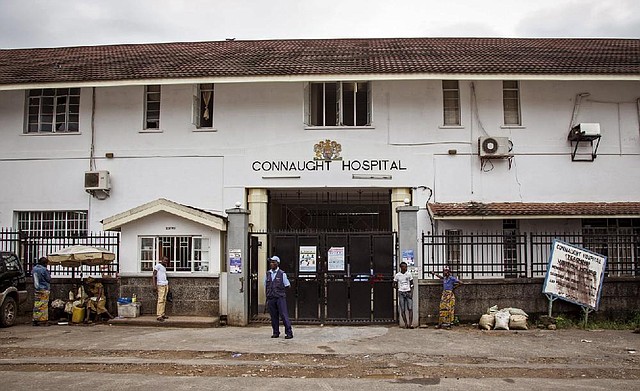 A security guard stands outside Connaught Hospital in Freetown, Sierra Leone, where a leading Ebola doctor died Wednesday from the virus.