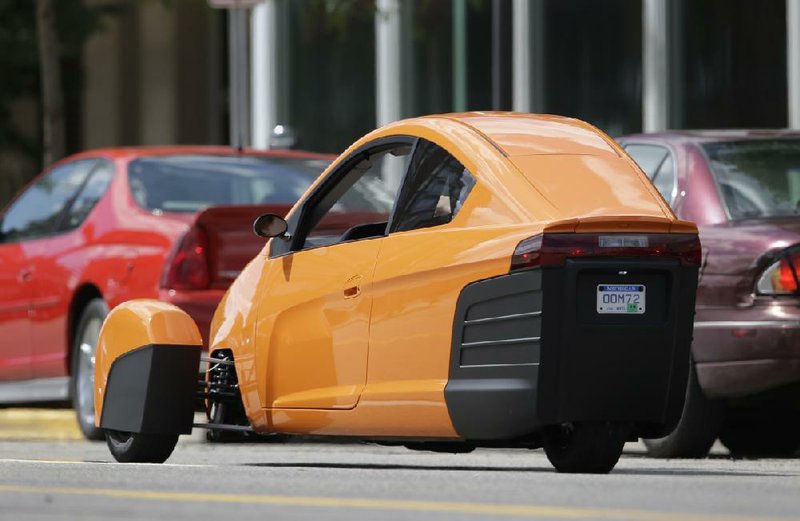 The Elio, a three-wheeled prototype vehicle, is shown in traffic in Royal Oak, Mich., Thursday, Aug. 14, 2014. Instead of spending $20,000 on a new car, Paul Elio is offering commuters a cheaper option to drive to work. His three-wheeled vehicle The Elio will sell for $6,800 car and can save on gas with fuel economy of 84 mpg. (AP Photo/Paul Sancya)