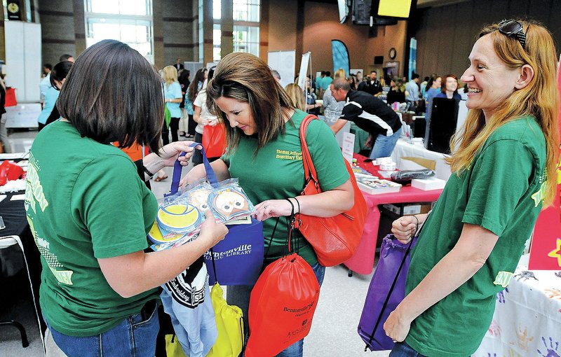 STAFF BEN GOFF &#8226; @NWABenGoff Holly Haak, from left, Audrey Perkins and Cristine Eubanks, all kindergarten teachers from Thomas Jefferson Elementary School, organize bags Friday stuffed full of handouts from vendors during Bentonville School District&#8217;s back-to-school celebration for teachers at Bentonville High School.