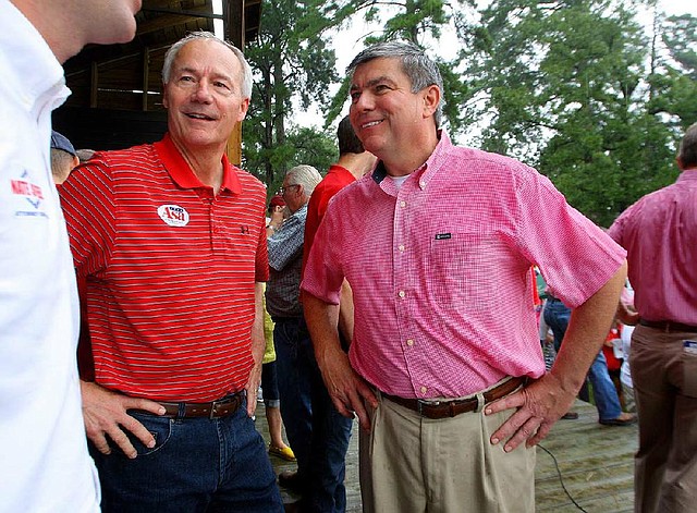 Republican gubernatorial candidate Asa Hutchinson (left) and Democratic candidate Mike Ross attend the Hope Watermelon Festival on Aug. 9. Between them they’ve reported raising $6.3 million for their campaigns and have filed only paper reports on the donations and spending.