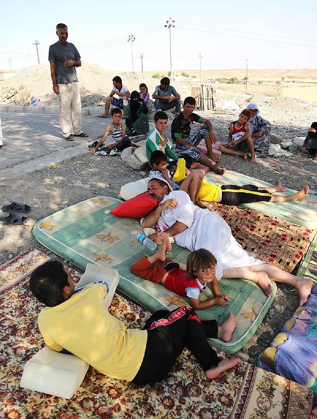 Displaced Iraqis from the Yazidi community settle at the Qandil mountains near the Turkish border outside Zakho, 300 miles (475 kilometers) northwest of Baghdad, Iraq, Saturday, Aug. 16, 2014. Islamic extremists shot 80 Yazidi men to death in Iraq, lining them up in small groups and opening fire with assault rifles before abducting their wives and children, officials and eyewitnesses reported Saturday. (AP Photo/ Khalid Mohammed)