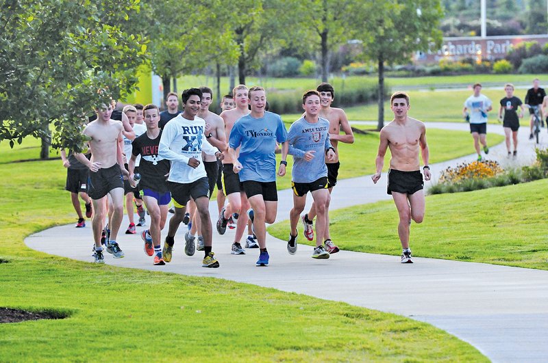  Staff Photo Spencer Tirey Miguel Contreras, front left, Nathan Ley, Connor Disney and Joshua Kruse run with other members of the Bentonville High School&#8217;s boys cross county team early Friday morning, Friday on the Blowing Springs Trail in Bentonville.