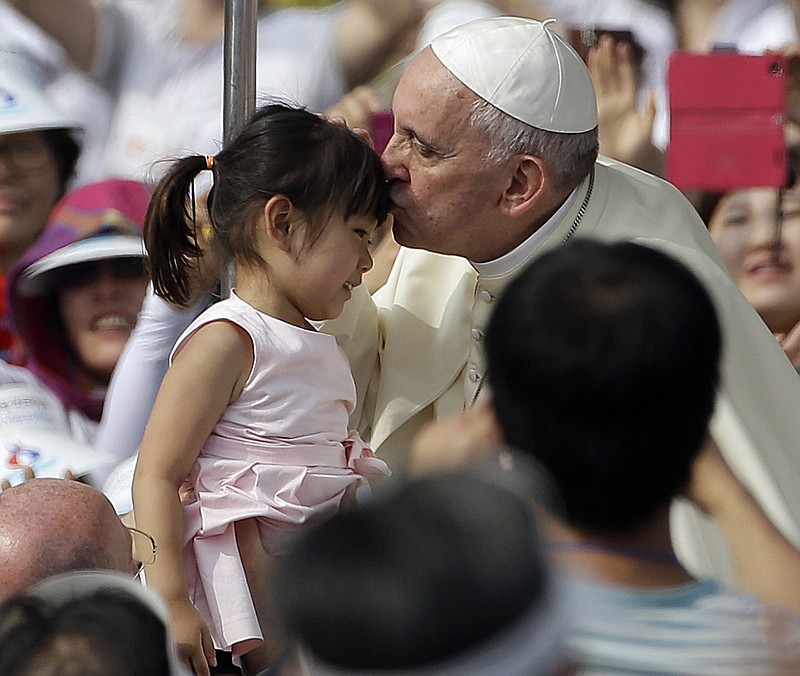 The Associated Press HONOR: Pope Francis, right, kisses a girl as he arrives with the popemobile to celebrate a mass and the beatification of Paul Yun ji-Chung and 123 martyr companions at Gwanghwamun Gate in Seoul, South Korea, Saturday. Paul Yun Ji-Chung, born in 1759, was among the earliest Catholics on the Korean peninsula.