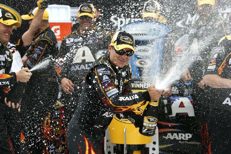 Jeff Gordon sprays champagne after his victory in the NASCAR Sprint Cup Series Pure Michigan 400 auto race at Michigan International Speedway in Brooklyn, Mich., Sunday, Aug. 17, 2014. (AP Photo/Bob Brodbeck)