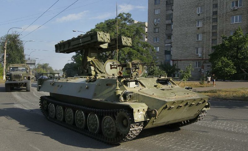 A Pro-Russian missile launcher drives in the town of Krasnodon, eastern Ukraine, Sunday, Aug. 17, 2014. A column of several dozen heavy vehicles, including tanks and at least one rocket launcher, rolled through rebel-held territory on Sunday.(AP Photo/Sergei Grits)