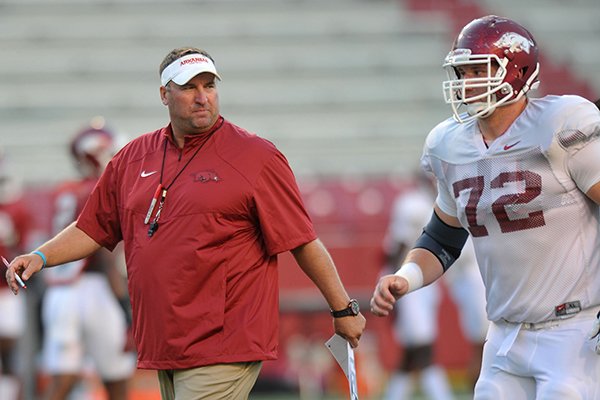 Arkansas coach Bret Bielema talks with center Frank Ragnow during a practice on Wednesday, Aug. 13, 2014 at Razorback Stadium in Fayetteville. 