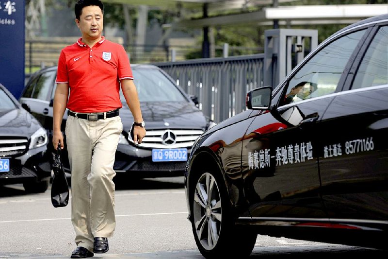 A man walks past Mercedes-Benz cars parked outside the dealer sales showroom in Beijing, China Monday, Aug. 18, 2014. China's government said Monday it has concluded Mercedes-Benz violated anti-monopoly law and charged excessive prices for parts, adding to a growing number of global automakers snared in an investigation of the industry. (AP Photo/Andy Wong)