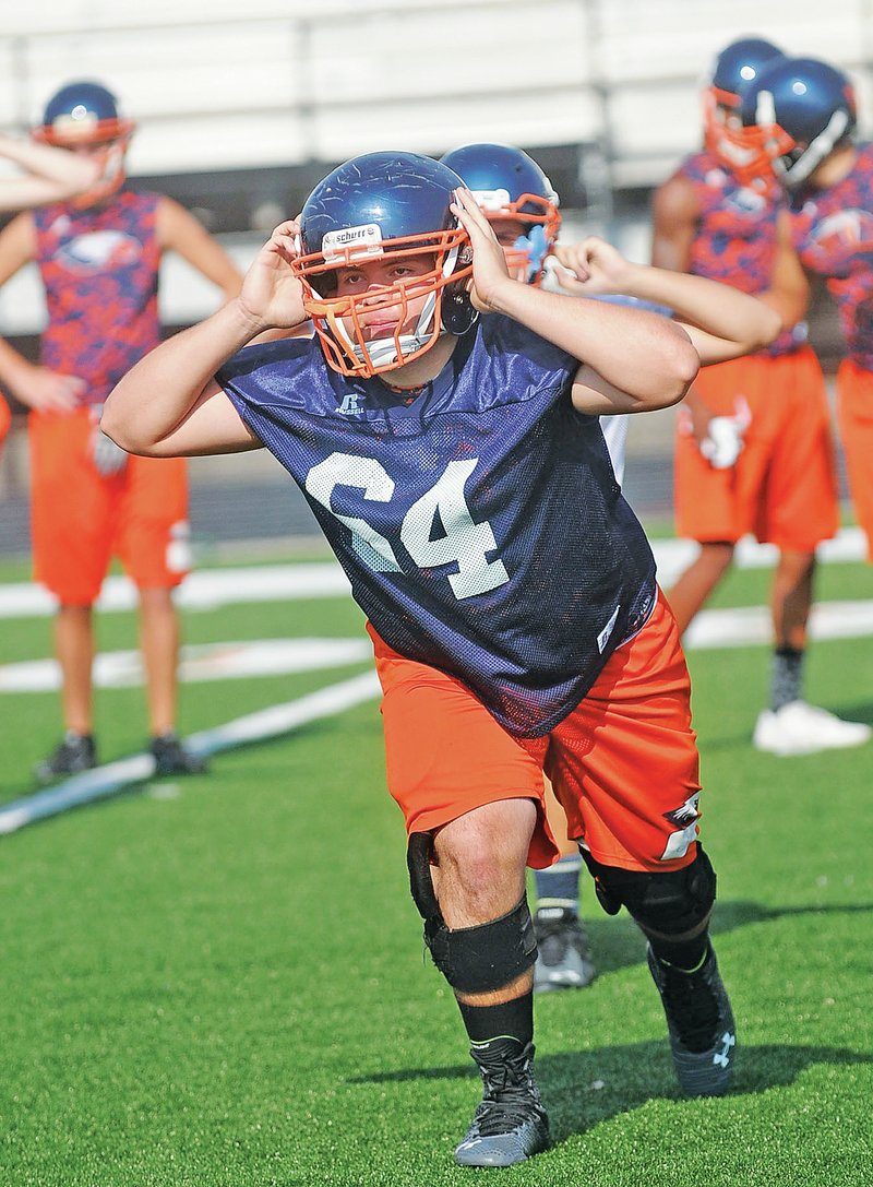 FILE PHOTO FLIP PUTTHOFF Kevin Merlos works out Aug. 5 with his Rogers Heritage lineman teammates at practice.