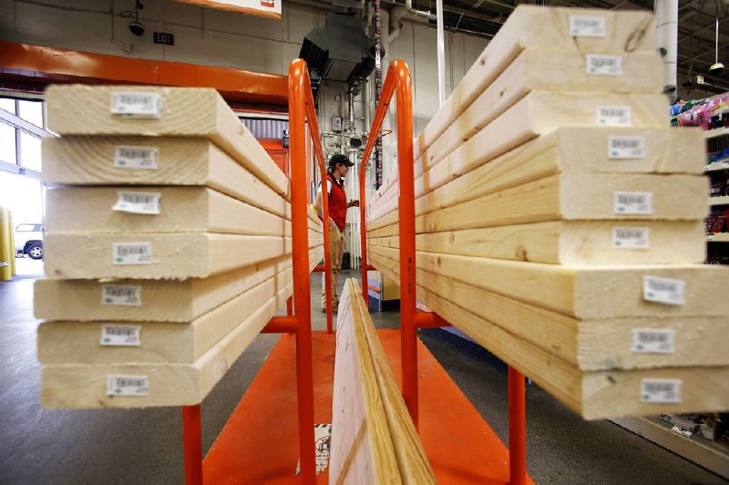 A shopper pays for lumber at a Home Depot in Boston in May. Home Depot reported a second-quarter profit of $2.05 billion, up from $1.8 billion a year ago.