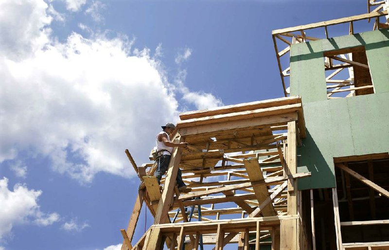 A worker clings to the frame of a house being built in Belmar, N.J., on July 30. Home construction increased 15.7 percent in July, the Commerce Department reported Tuesday.
