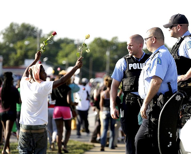 Police watch as protesters march Tuesday in Ferguson, Mo., for Michael Brown, killed there Aug. 9.