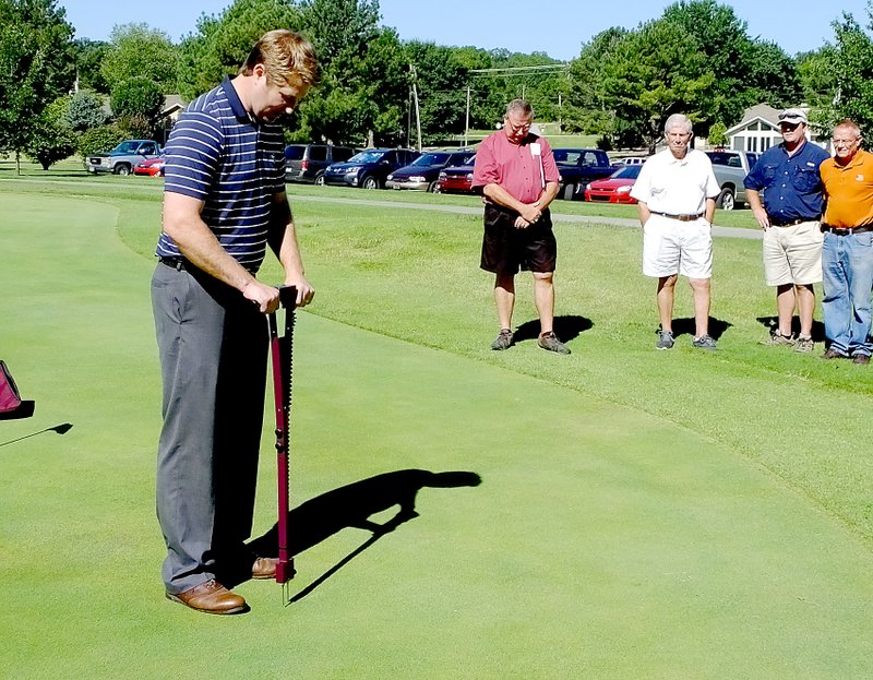 Lynn Atkins/The Weekly Vista Ty McClellan of the United States Golf Association demonstrates a moisture meter on the practice green at the Scotsdale Golf Course. The instrument will allow workers to determine exactly how much water is needed in each area, he said.