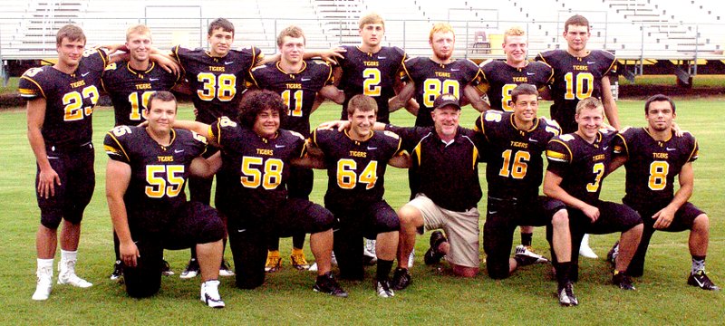MARK HUMPHREY ENTERPRISE-LEADER Prairie Grove head football coach Danny Abshier poses with his 14 seniors during media day. The season gets underway Friday as the junior high and varsity Prairie Grove football units hold their annual scrimmage with split squads competing in the Black and Gold game at 6:30 p.m. at Tiger Den Stadium.