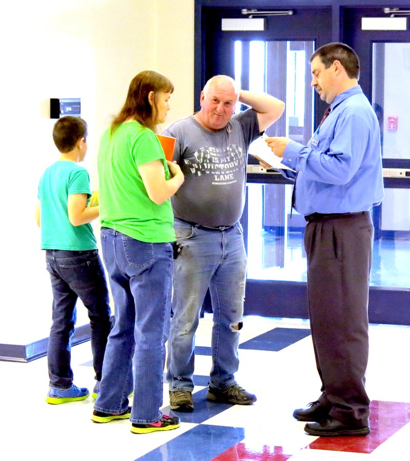 Photo by Mike Eckels Cary Stamps (far right) greeted parents and students as they arrived to pick up their student packets during open house at Decatur&#8217;s Northside Elementary Aug. 14.