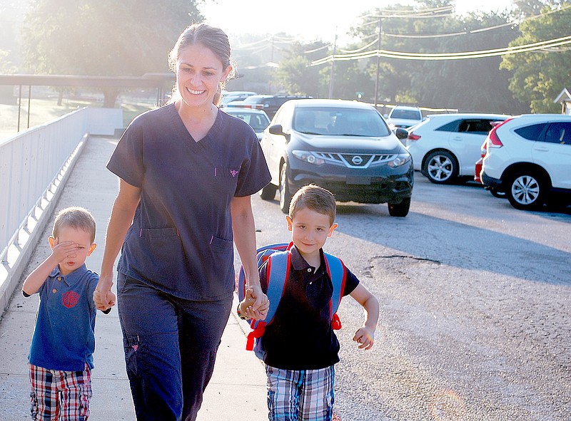 Graham Thomas/Herald-Leader Parker Watson, right, walked into Northside Elementary on Monday for his first day of kindergarten with his mom Julie Glenn and younger brother Cooper Watson.