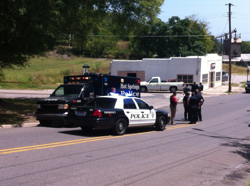 Hot Springs police, shown here at the corner of Locust and Spring, investigate a shooting involving three victims Wednesday afternoon. 