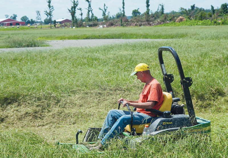 Tim Grantham, working under the National Emergency Grant program, mows the softball and baseball fields at Vilonia as work begins to try and bring the fields back from the tornado that destroyed them earlier this year.