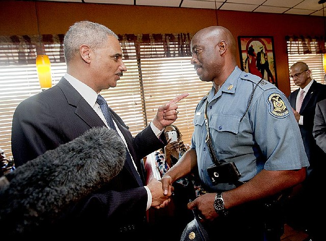 U.S. Attorney General Eric Holder (left) talks with Missouri State Highway Patrol Capt. Ron Johnson on Wednesday at a restaurant in Ferguson, Mo., where Holder also visited with customers.