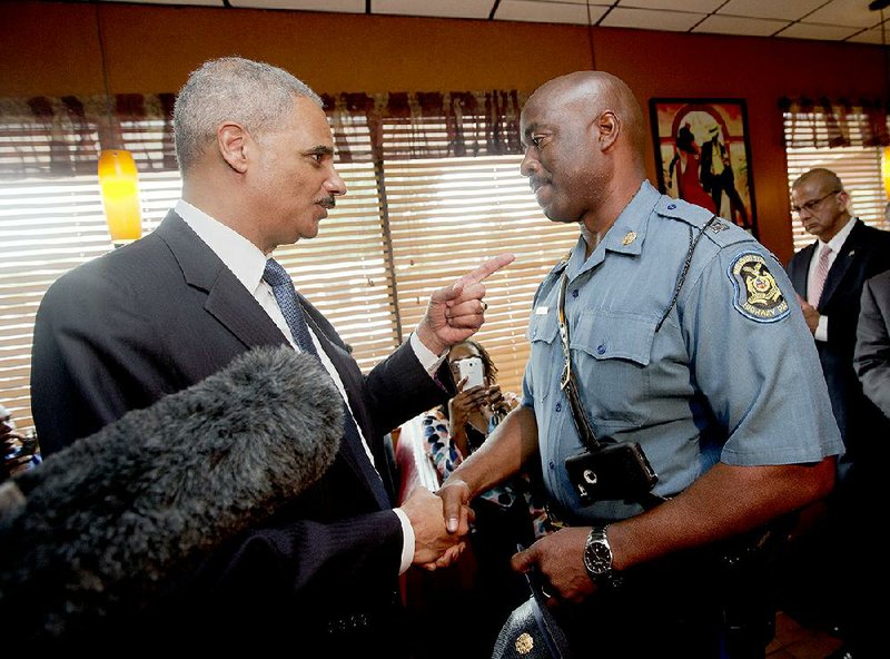 U.S. Attorney General Eric Holder (left) talks with Missouri State Highway Patrol Capt. Ron Johnson on Wednesday at a restaurant in Ferguson, Mo., where Holder also visited with customers.