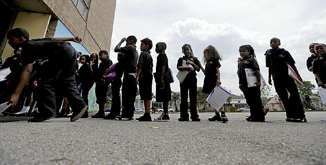 Students wait in line at a charter school in New Orleans, where overall school enrollment is down about 31 percent from pre-Katrina days.