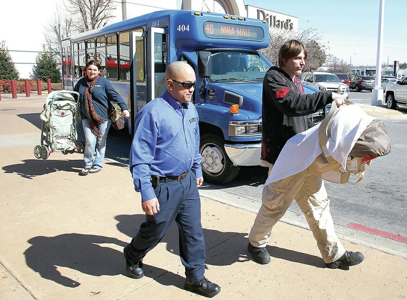 FILE PHOTO DAVID GOTTSCHALK Riders exit an Ozark Regional Transit bus in Fayetteville.