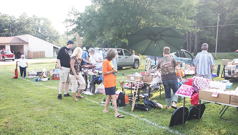 The Sentinel-Record/Jeff Smith BARGAIN HUNTERS: Shoppers arrived early Saturday morning looking for bargains at the inaugural Junk in the Trunk fundraiser by the Lake Hamilton Fire and Rescue Department.