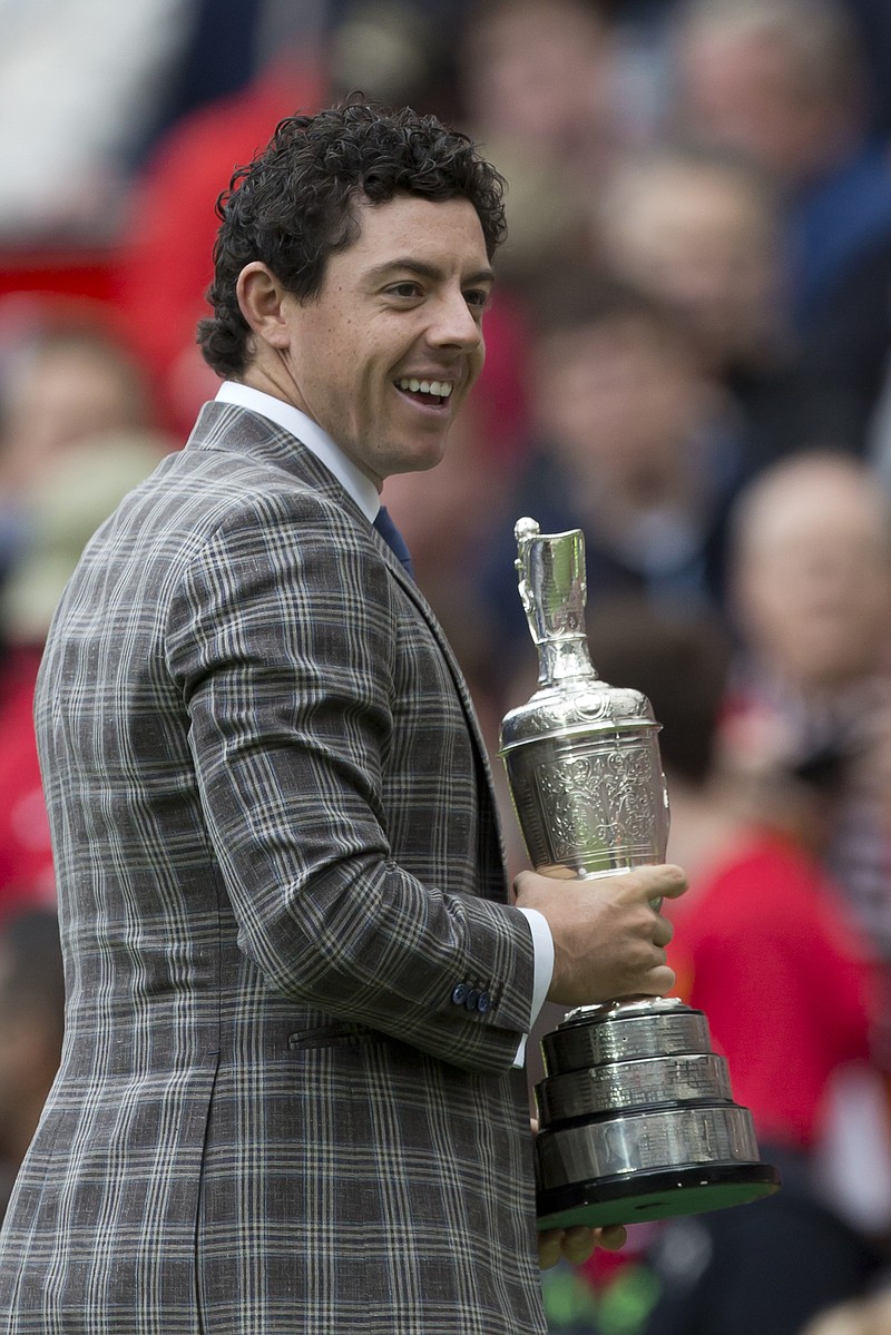 The Associated Press PITCH MAN: Rory McIlroy clutches the Claret Jug, the British Open championship trophy, as he is introduced to the crowd at halftime of Manchester United's English Premier League soccer match Saturday against Swansea City. Visiting Swansea scored a stunning upset, 2-1.