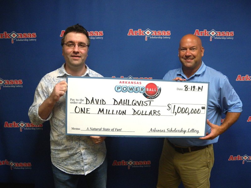 David Dahlqvist, left, holds his $1 million lottery check with the held of Arkansas Scholarship Lottery Director Bishop Woosley, right.