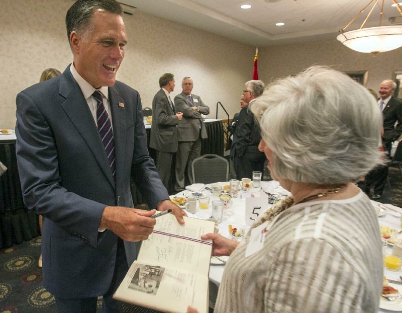 Arkansas Democrat-Gazette/BENJAMIN KRAIN --08/21/2014--
MA Governor Mitt Romney autographs a book during an Arkansas state Republican party breakfast  Thursday morning at the Wyndham Riverfront North Little Rock. Romney was in Arkansas to endorses US Rep Tom Cotton, R-Ark, as a candidate for US Senate.