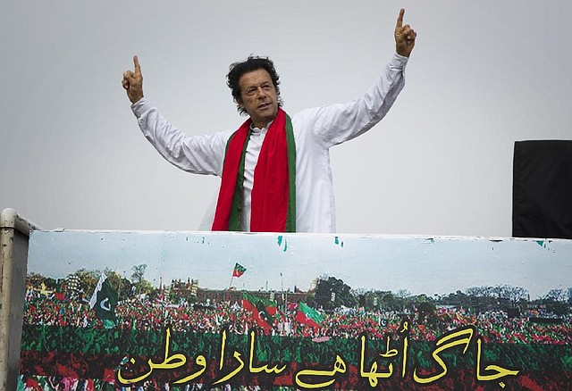 Pakistan's cricketer-turned-politician Imran Khan waves to his supporters gathering near parliament in Islamabad, Pakistan, Thursday, Aug. 21, 2014. Thousands of Khan's supporters are besieging parliament for a second day Thursday to pressure Prime Minister Nawaz Sharif to resign over alleged election fraud. Writing at the bottom reads, "Country is awaken." (AP Photo/B.K. Bangash)