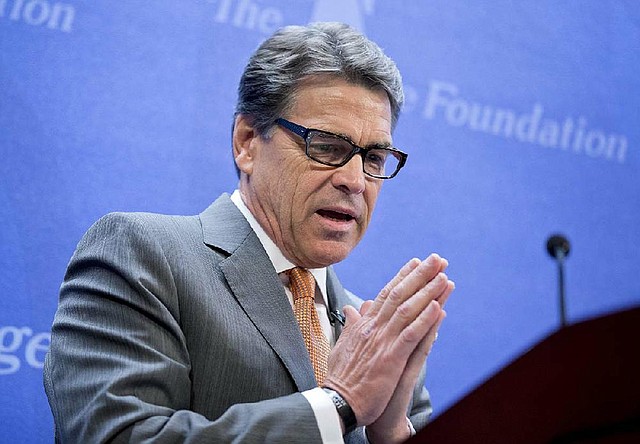 Texas Gov. Rick Perry gestures as he speaks at the Heritage Foundation in Washington, Thursday, Aug. 21, 2014, about that he would be open to sending U.S. combat forces to Iraq to fight the deadly Islamic state after its attacks on a Christian minority and the beheading of an American journalist and border security. (AP Photo/Manuel Balce Ceneta)