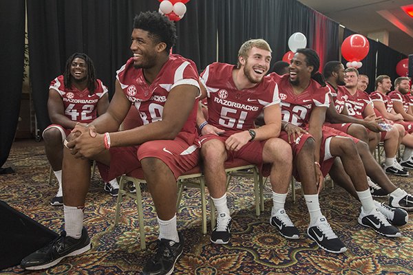 Deatrich Wise Jr., from left, Brooks Ellis and Daunte Carr, all with the University of Arkansas football team, laugh Friday, Aug. 22, 2014 while the teammates introduce each other at the 2014 Arkansas Football Kickoff Luncheon at the Northwest Arkansas Convention Center in Springdale.