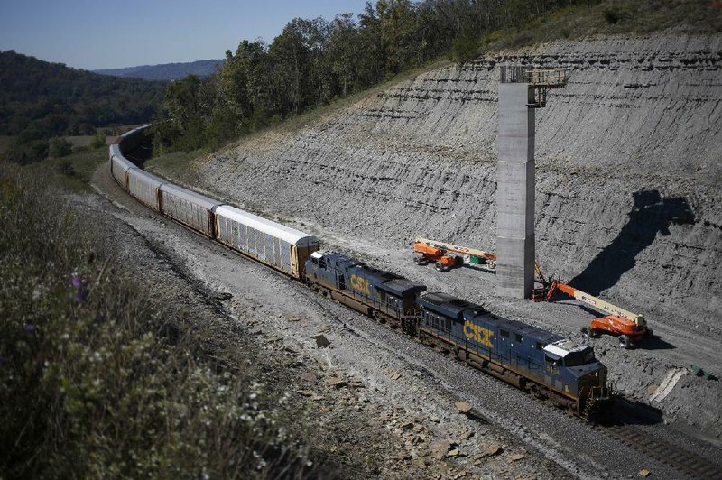A CSX Corp. train hauling vehicles passes through a gap that was once the Eagle Tunnel in Glencoe, Ky., in this 2013 photo. Rising rates for rail freight have shippers such as Dow Chemical Co. asking for government intervention.