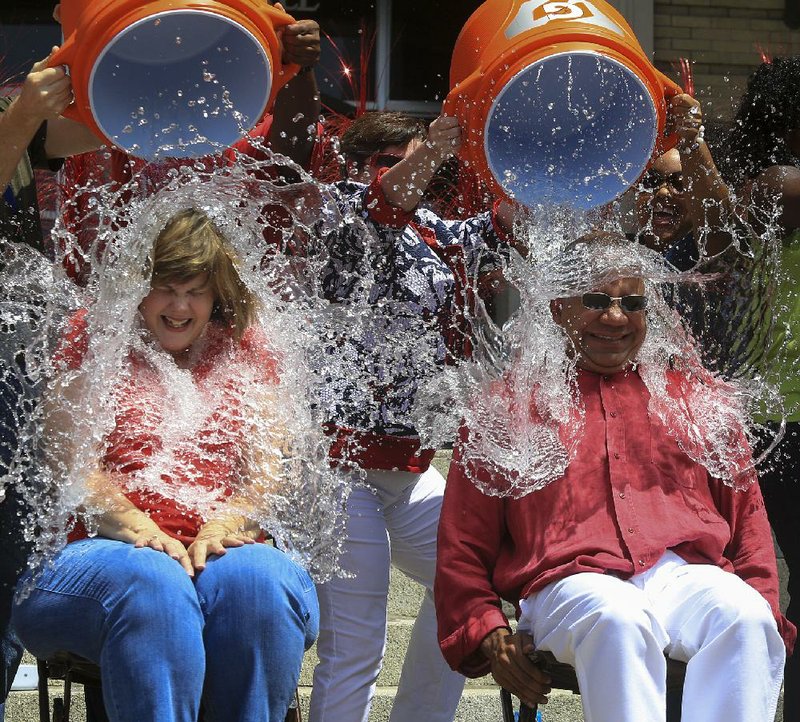  Arkansas Democrat-Gazette/STATON BREIDENTHAL --8/22/14-- Little Rock  Finance Director Sara Lenehan (left) and Little Rock City Manager Bruce Moore get a bucket of ice water over their heads Friday at City Hall as they take the ALS ice bucket challenge with other department heads from the city. In addition to a $500 donation from the city, city employees raised $160 by making donations to enter a drawing for the chance to dump the ice water on their bosses. The money went to the Arkansas Chapter of the ALS Association.