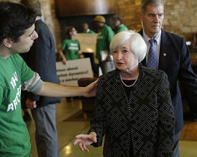 Federal Reserve Chairman Janet Yellen speaks with a protester as she arrives for dinner Thursday during the Federal Reserve Bank of Kansas City’s conference at the Jackson Lake Lodge near Jackson Hole, Wyo.