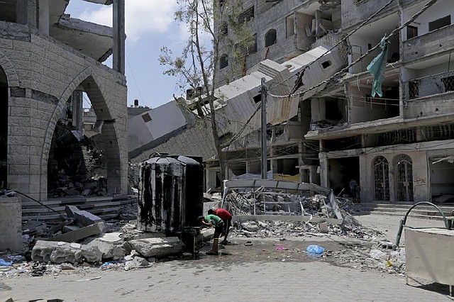 Palestinian children at a refugee camp in Gaza City wash their faces in the ruins of the Al-Sousi mosque before Friday prayers.