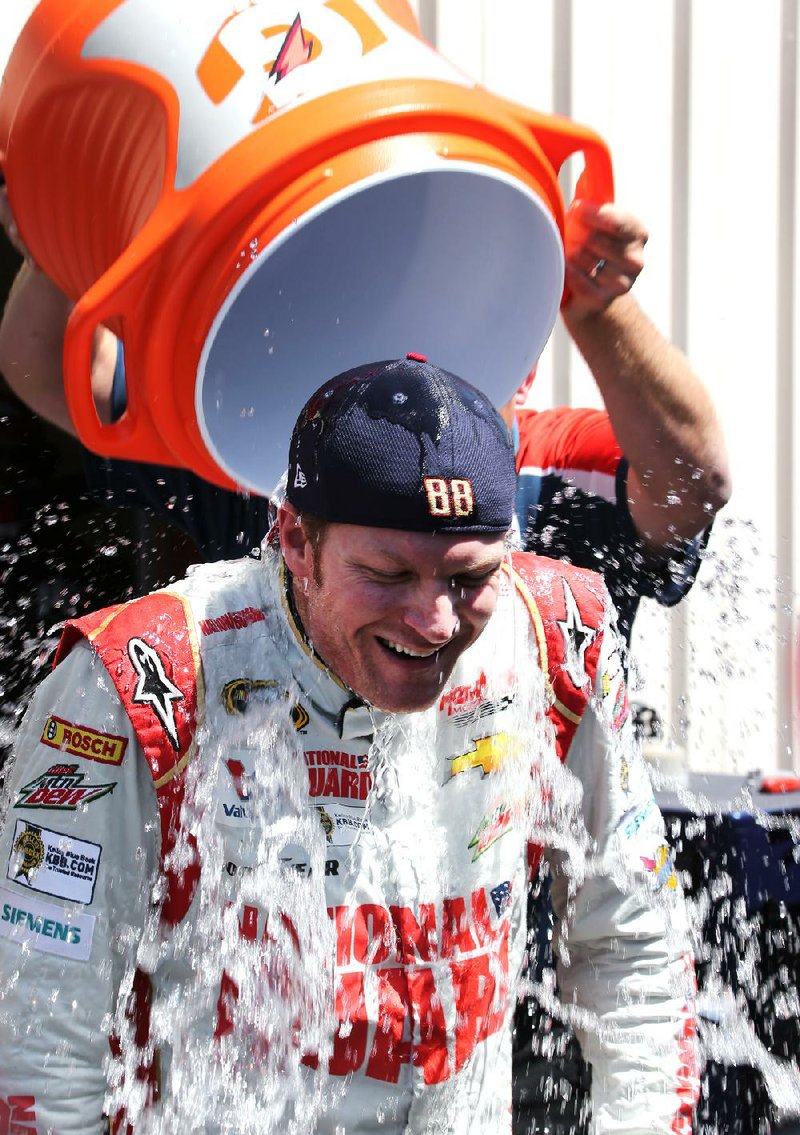 Dale Earnhardt Jr. smiles while taking the ice bucket challenge after practice for the NASCAR Sprint Cup Series auto race at Michigan International Speedway in Brooklyn, Mich., Friday, Aug. 15, 2014. The challenge, in which participants get a bucket of water and ice cubes dumped on their heads, raises money to fight ALS, or Lou Gehrig's disease. (AP Photo/Bob Brodbeck)